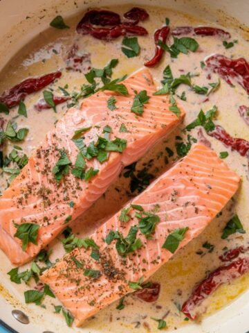 Marry Me Salmon Recipe – A creamy Tuscan-style salmon dish featuring tender salmon fillets simmered in a rich garlic parmesan sauce with sun-dried tomatoes and fresh herbs. A flavorful and easy one-pan dinner recipe.