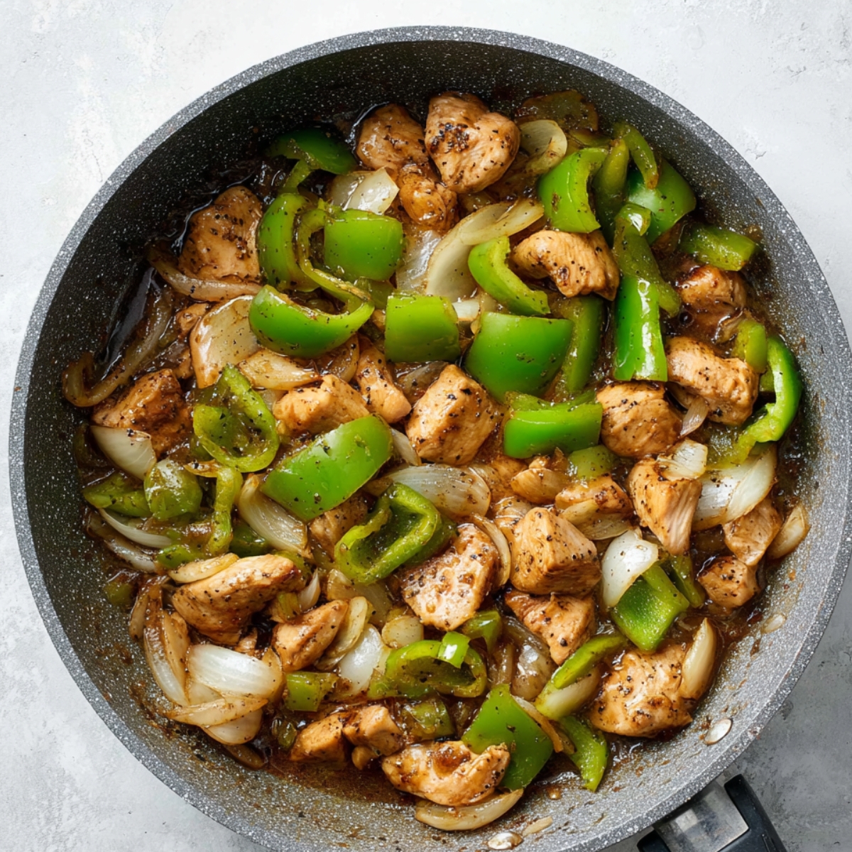 Easy Black Pepper Chicken Recipe 13 Stir-fried black pepper chicken with green bell peppers and onions in a pan