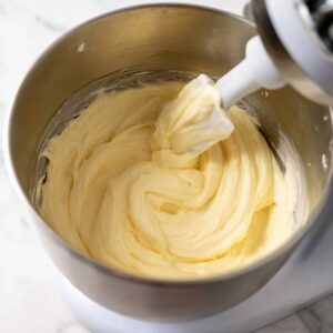 Lemon Blueberry Cupcakes Recipe (Moist & Easy!) 18 Smooth lemon cupcake batter being mixed with a paddle attachment in a stand mixer, showing a thick and fluffy consistency.