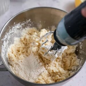 Lemon Meltaway Cookies Recipe (Ready in 33 Minutes!) 15 "A close-up view of lemon meltaway cookie dough being mixed in a metal bowl. The dough looks smooth and slightly crumbly, with flour visible in the mixture."