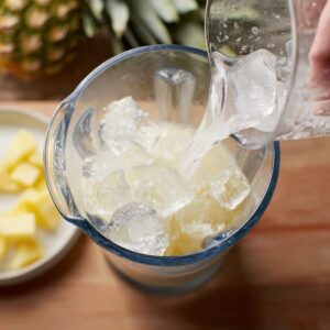 Delicious Piña Colada Recipe 14 In the second image, you see ice being added to the blender. Ice is essential for giving the Pina Colada its signature frozen texture.