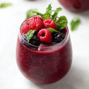 5-Minute Red Wine Slushies Recipe | Frozen Sangria 15 Glass of frozen red wine berry slushie topped with raspberries, blackberries, and fresh mint leaves