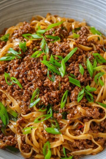 Easy Mongolian Ground Beef Noodles 13 Mongolian ground beef noodles topped with sliced green onions, served in a ceramic bowl, ready to eat.