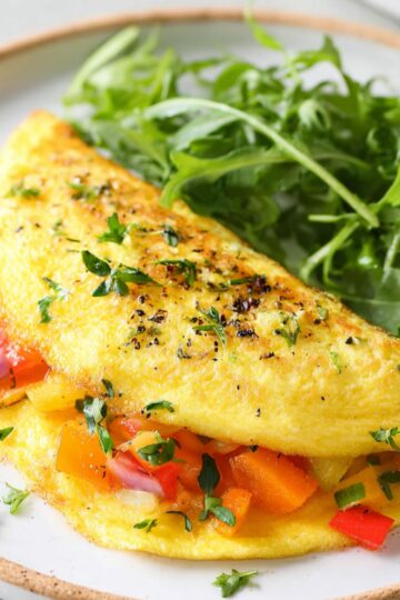 Best Omelette Recipe 8 omelette recipe Top-down view of beaten eggs in a ceramic bowl with black pepper seasoning, fork inside bowl, airy egg texture, neutral background, clean minimal food prep photography, soft lighting, realistic detail