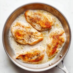 Creamy Mushroom Chicken Recipe 14 Pan-seared chicken breasts seasoned with pepper cooking in butter in a skillet