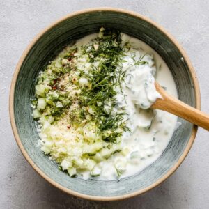 Healthy Greek Bowl Recipe with Chicken & Tzatziki (35 Min) 14 Homemade tzatziki sauce made with Greek yogurt, grated cucumber, garlic, fresh dill, and salt in a mixing bowl