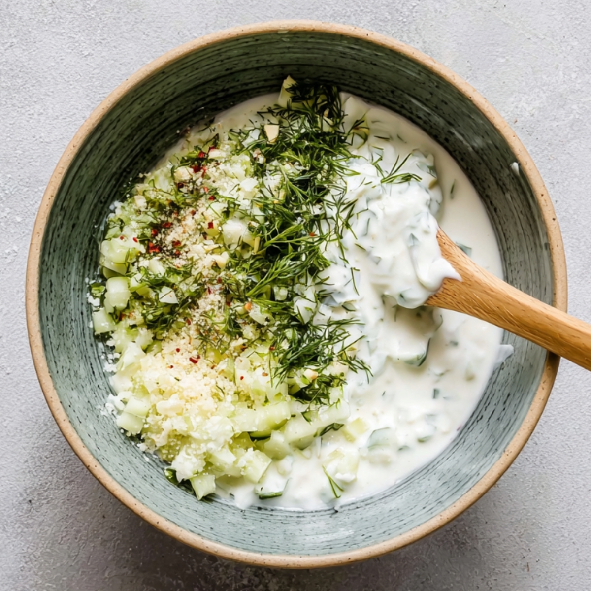 Healthy Greek Bowl Recipe with Chicken & Tzatziki (35 Min) 10 Homemade tzatziki sauce made with Greek yogurt, grated cucumber, garlic, fresh dill, and salt in a mixing bowl