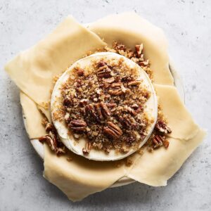 Easy Baked Brie in Puff Pastry Recipe 15 Brie cheese topped with brown sugar and chopped pecans on puff pastry before baking