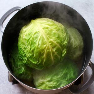 Cabbage Rolls Recipe 15 A whole head of cabbage steaming in a large pot to soften the leaves for making stuffed cabbage rolls