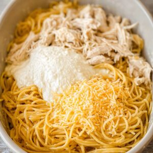 Chicken Spaghetti Casserole Recipe, Easy & Creamy! 16 A photo of the casserole dish with chicken spaghetti topped with melted cheese, possibly before baking.