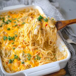 Chicken Spaghetti Casserole Recipe, Easy & Creamy! 17 A photo of chicken spaghetti casserole being served, showing layers of cheese and chicken with pasta.