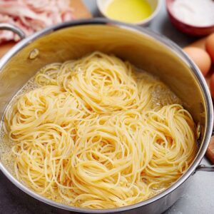 Chicken Spaghetti Casserole Recipe, Easy & Creamy! 15 A photo of a homemade chicken spaghetti casserole on a plate, showing a cheesy and creamy texture with chicken pieces visible.