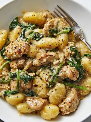A close-up of Creamy Chicken and Gnocchi in a bowl, featuring tender chicken, soft gnocchi, and a creamy sauce, garnished with freshly cracked black pepper.